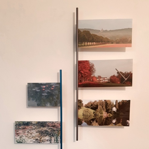 Zwei Cartes-Bilderleisten mit je zwei und drei Postkarten von Landschaften – vertikal an der Wand aufgehängt.